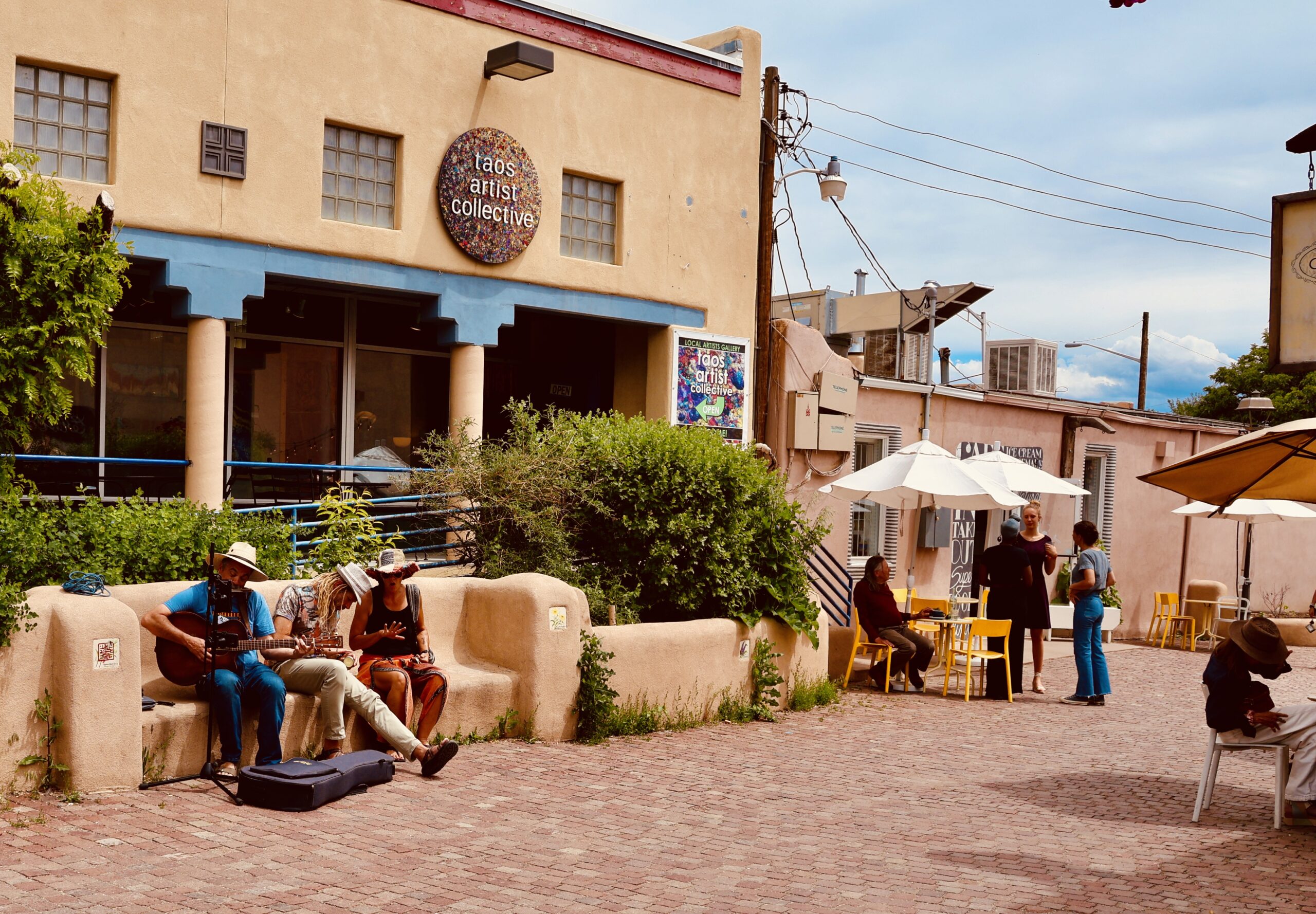 Musicians and tourists on streets outside art galleries in Taos, NM