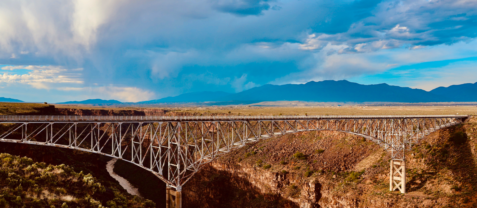 Sunset over the Rio Grande Gorge Bridge with mountains in the background