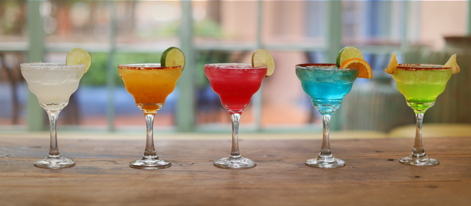 Colorful margarita glasses on bar