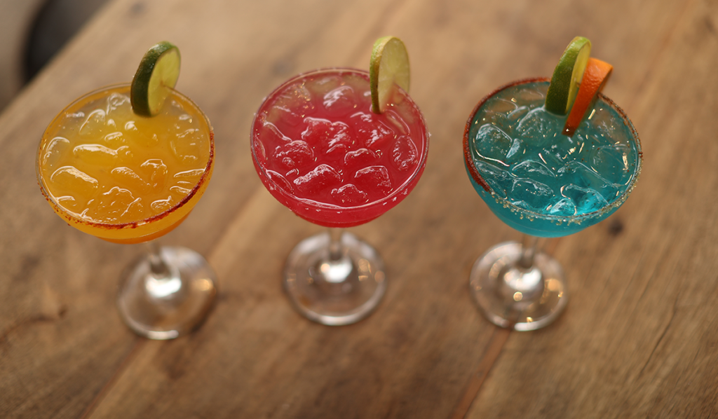 Colorful margarita glasses on bar