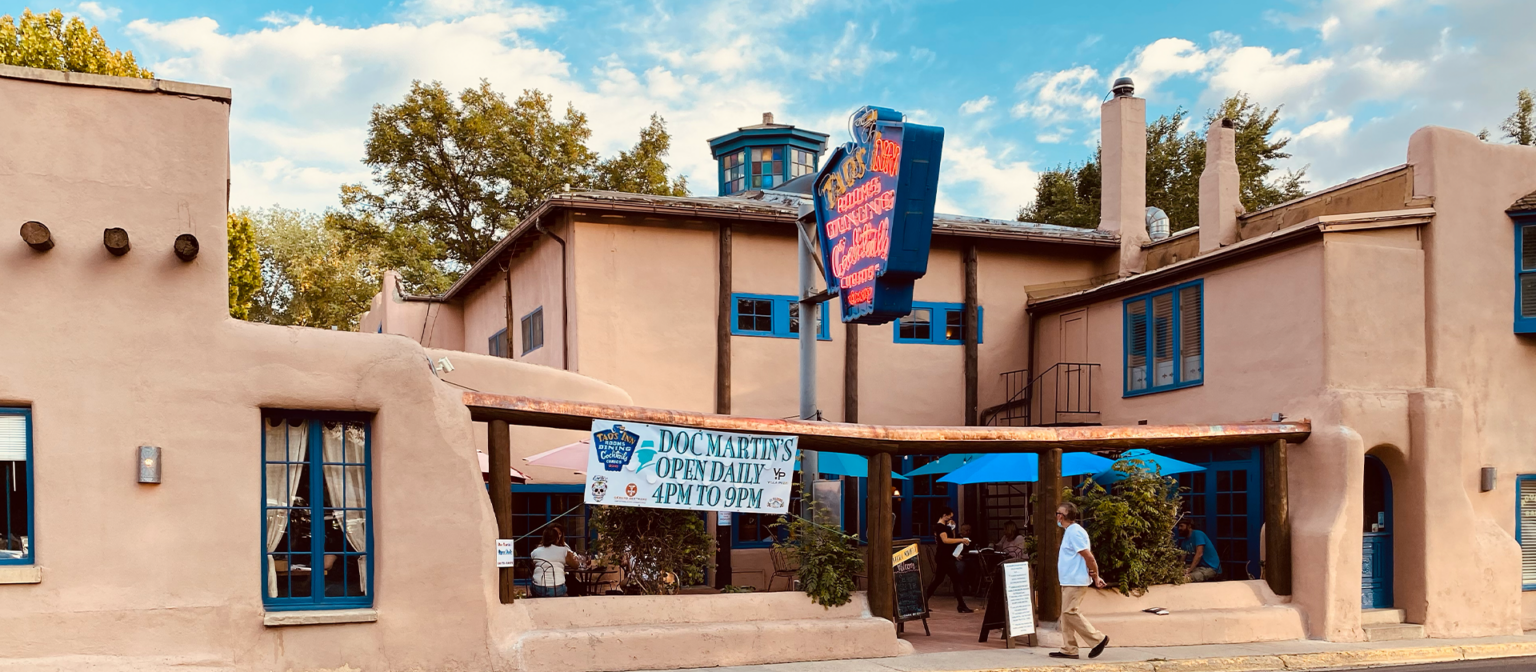 Front view of Taos Inn building and sign with patio