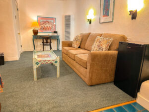 Seating area, desk, and refrigerator in deluxe king room