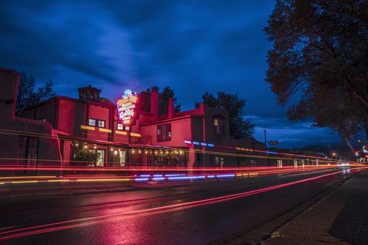 Taos Inn from the street at night with traffic lights blurring by