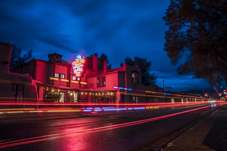 Taos Inn from the street at night with traffic lights blurring by