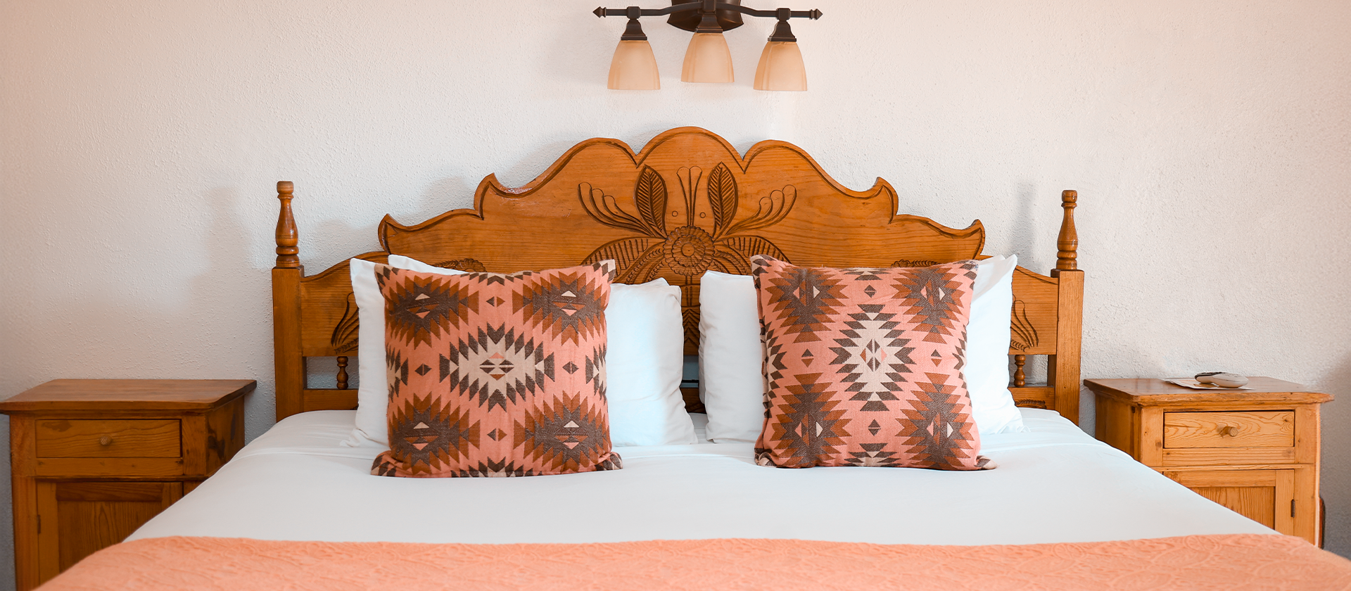 Carved wooden headboard and western pillows on bed