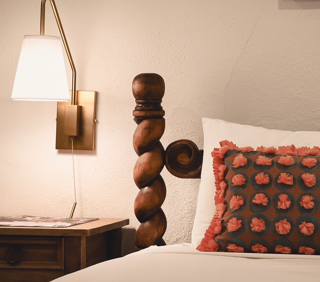 Bedside lamp and pillows in Taos Inn room