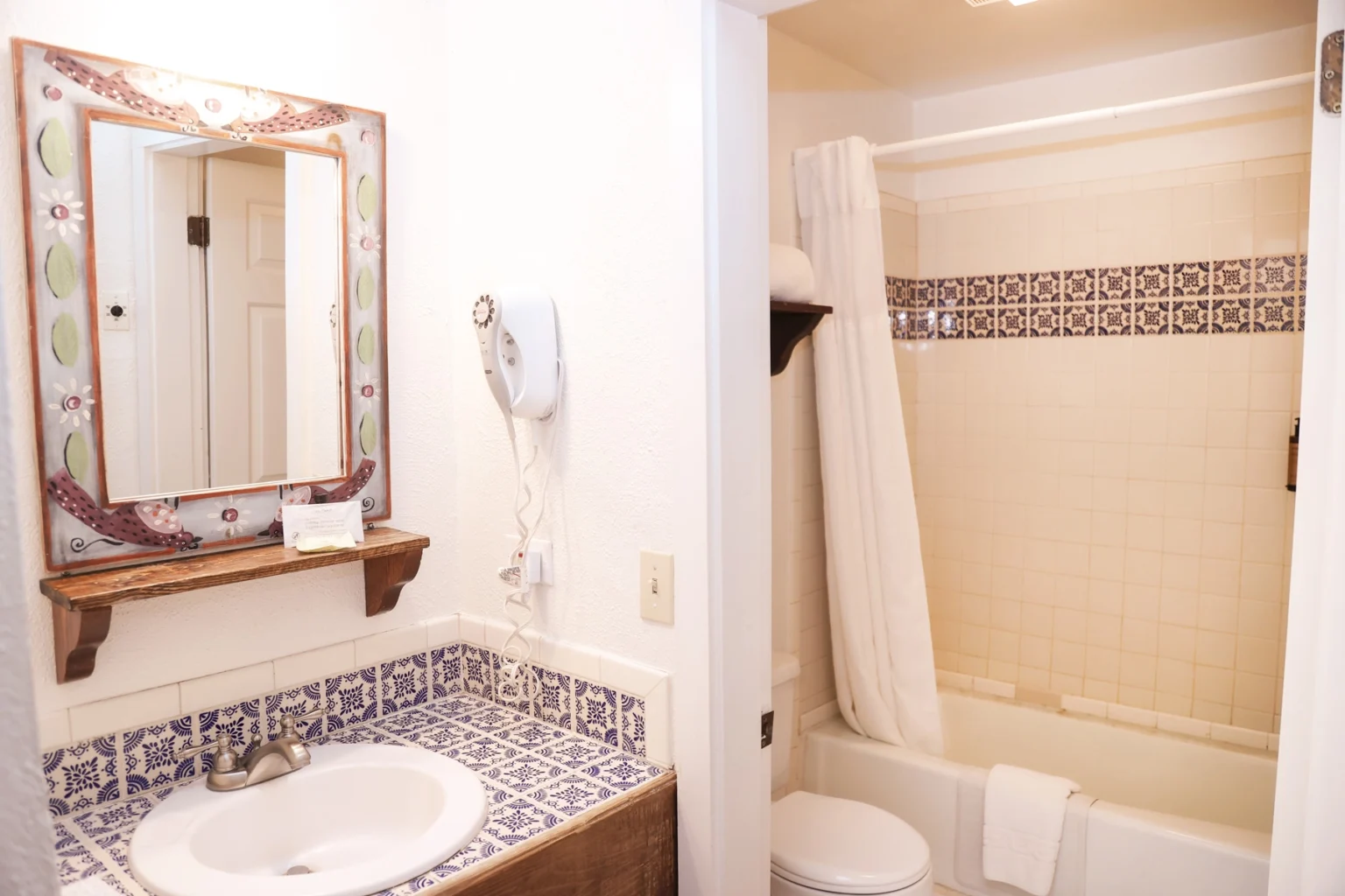 Ensuite bathroom sink, vanity, toilet, and tub in standard queen room