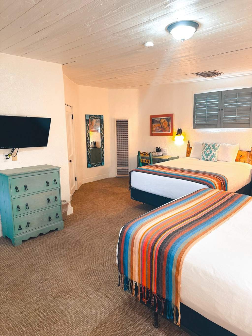 Two queen beds in room with desk and fireplace