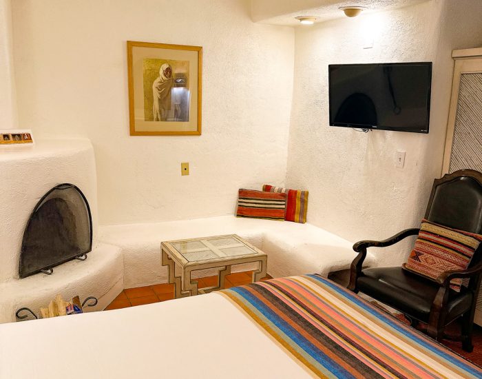 Bed, fireplace, television, and seating in queen suite